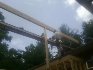 Carpenter setting a ridge beam over a new addition frame — Ice Dam Removal by Roofing Brothers in Lincroft