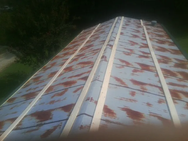 Rusted metal roof panels with new wood purlins before replacement — Storm Damage Roof Repair in Lincroft by Roofing Brothers