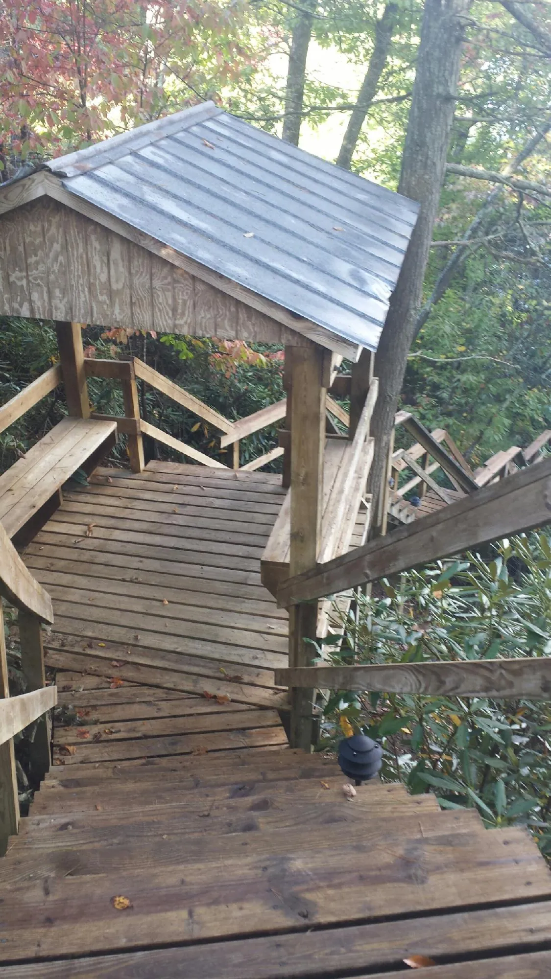 Metal roofed shelter over wooden steps on a wooded walkway — Skylight Repair & Installation work by our crew in Lincroft