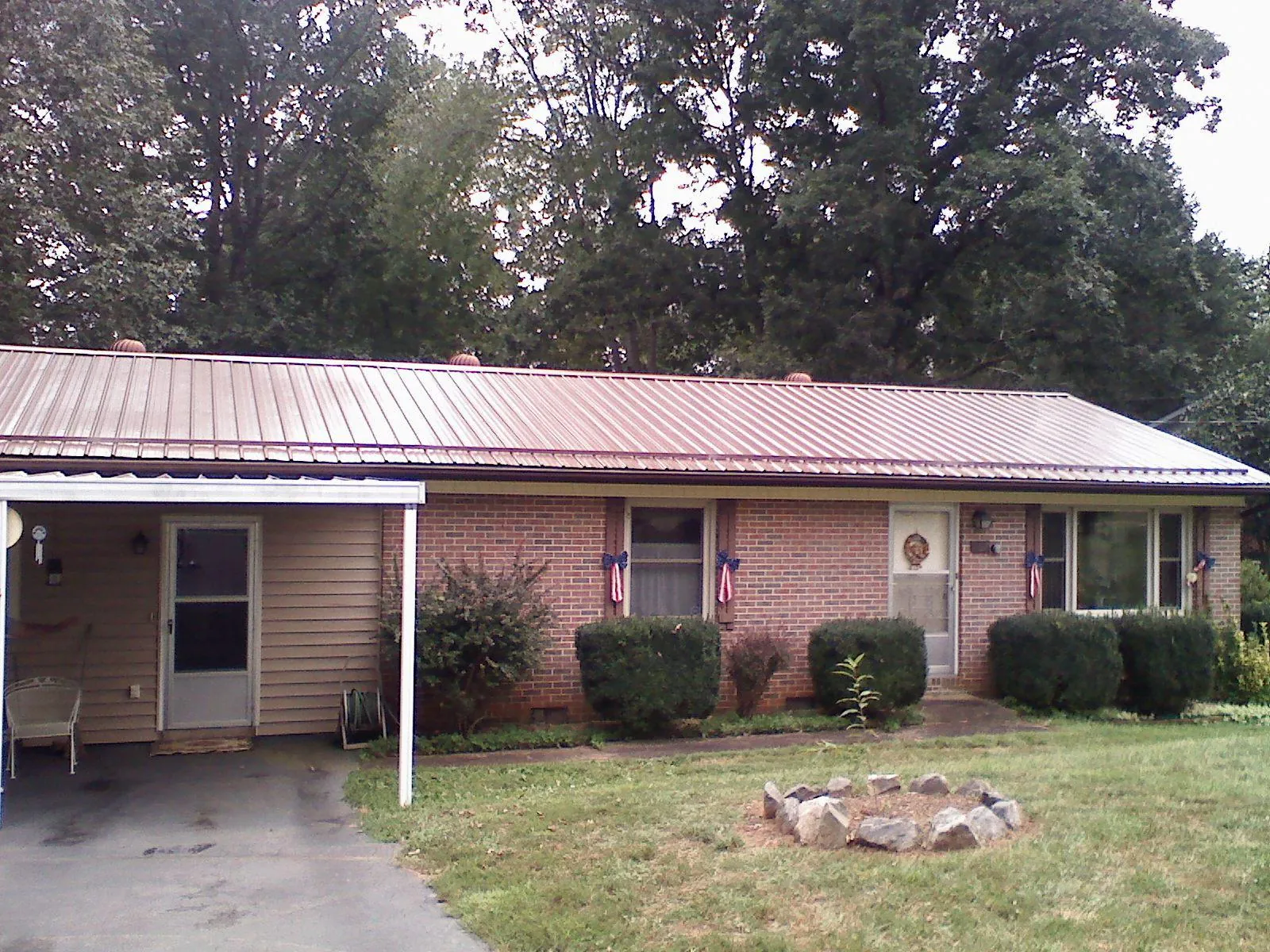 Bronze metal roof and carport on a brick ranch home — Roof Repair work by our crew in Lincroft